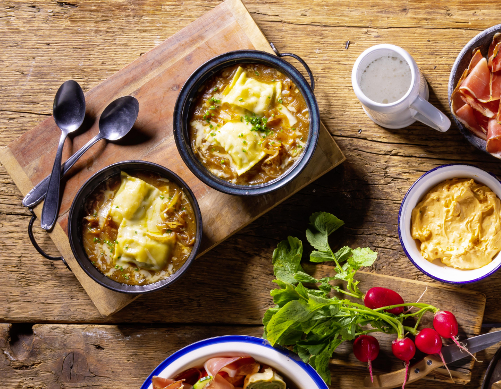 Zwiebelsuppe mit Käse überbackenen Maultaschen und Schnittlauch